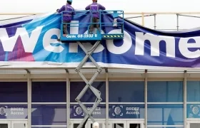Obreros trabajan en el aviso de bienvenida al Mobile World Congress en Barcelona.