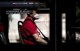Un usuario protegido con una mascarilla en un bus.