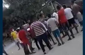 Agrupados, sin tapabocas, viendo la pelea de gallos.