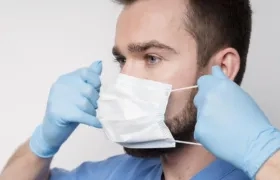 Un enfermero explica el uso del tapabocas.