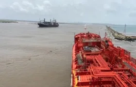 La motonave Calypso zarpando y en primer plano el Nordic Wolverine, encallado en Bocas de Ceniza.