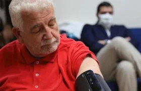 Un hombre espera mientras le toman la presión arterial. 