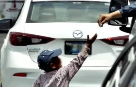 Mientras los niños se exponen a recibir el dinero, sus padres aguardan cerca para recibir la ganancia. 