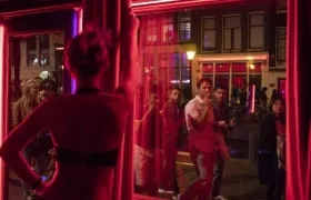 Jóvenes frente a uno de los escaparates del barrio Rojo de Amsterdam.