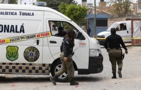 Policías municipales resguardan el área acordonada de una fosa clandestina en Jalisco, México.