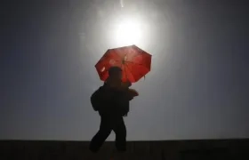 Una mujer camina resguardándose del sol con una sombrilla, en Córdoba, ayer. 