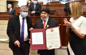 Julio Ernesto Estrada, recibiendo la condecoración por parte de los Representantes Jorge Gómez Vallejo y Jennifer Arias.