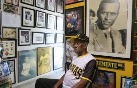 Justino, hermano de Roberto Clemente, rodeado de fotos del legendario beisbolista.