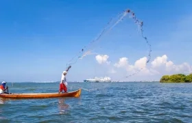 La perfecta armonía: la terminal y un pescador con su red lanzada y sostenida en el aire.