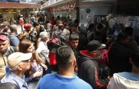 Migrantes venezolanos esperan para abordar los autobuses que los lleven hacia el municipio de Necoclí.