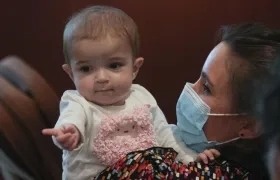 La pequeña Emma, de 13 meses, en brazos de su madre, Ana. 