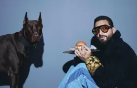 Maluma rodeado de hamburguesas y hot dogs (perros calientes).
