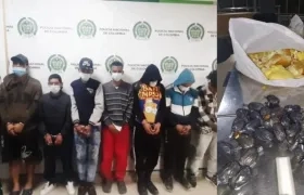 Capturados y parte de la droga incautada.