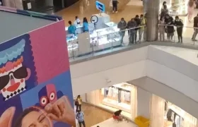 Varias personas miran hacia el primer piso donde quedó tendido el joven. 