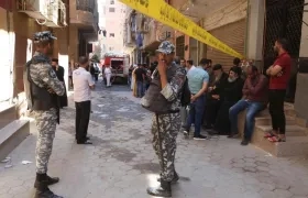 Personas y militares aguardan en las afueras de la iglesia que se incendió en El Cairo.