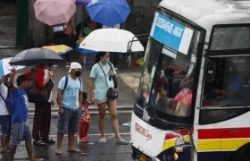 Ciudadanos de protegen de las lluvias con paraguas.