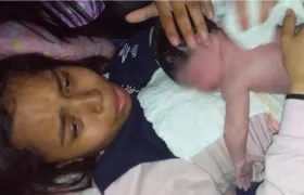 Karol Viviana Teherán Matute sostiene a su hija nacida en un bus de Brasilia.