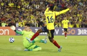 Óscar Cortés rematando frente al arquero uruguayo Lucas Rodríguez.