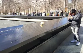 Un grupo de personas verificando las placas de las víctimas.