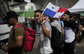 Migrantes de origen venezolano hacen fila para subir a un autobús hacia el aeropuerto internacional de Tocumen en Ciudad de Panamá.
