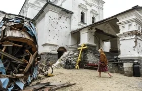 Una mujer ucraniana camina entre los destrozos producidos por la ofensiva rusa en una localidad de la región de Donetsk.