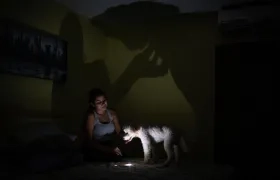 Una mujer usa la lámpara de su celular tras la falta de energía en Venezuela. 