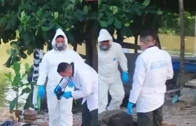 La Sijin realizando la inspección del cuerpo a orillas del río Magdalena. 
