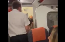 El asistente de vuelo abriendo la puerta del baño del avión.