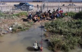 Migrantes esperan para cruzar el río Bravo hacía la frontera con Estados Unidos, este miércoles en Ciudad Juárez