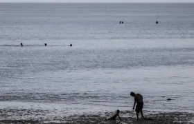 Un hombre y un niño se bañan en el Río de la Plata, en una fotografía de archivo