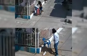 Hombre quitándole la ropa al muñeco.