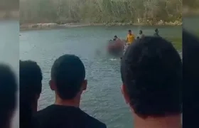 Personas rescatando de la Ciénaga de Mallorquín al adolescente.