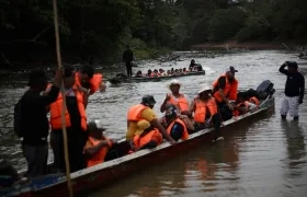Migrantes llegan en canoas a una estación de recepción migratoria luego de cruzar la selva del Darién, en Lajas Blancas, Panamá