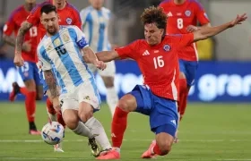 Lionel Messi disputa el balón con el chileno Igor Lichnovsky.
