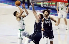 Luka Doncic intenta bloquear el lanzamiento de Jayson Tatum. 