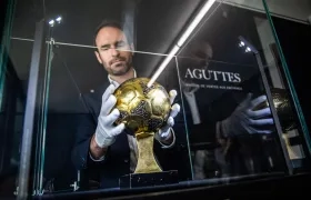 Francois Thierry, de la casa de subastas Aguttes, con el Balón de Oro de Maradona. 