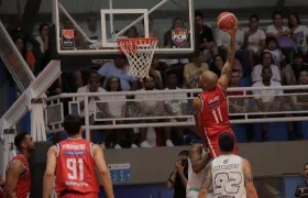 Ernesto Oglivie dirige el balón hacia la cesta para anotar dos puntos para Titanes.