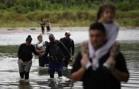 Migrantes cruzando el río Tuquesa luego de atravesar la selva del Darién, en Panamá.