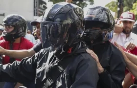 María Corina Machado (de casco negro) retirándose de la manifestación de este jueves.
