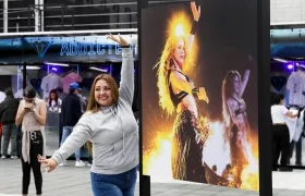 Una seguidora de Shakira posa junto a una foto de la cantante barranquillera. 