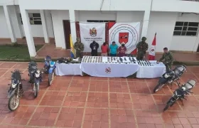 Cuatro de los capturados y armas incautadas. 