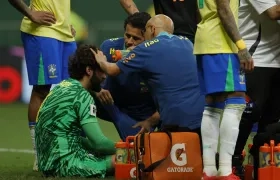 Alisson Becker recibe atención médica tras chocar con el colombiano Dávinson Sánchez. 