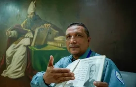 Jairo Enrique Padilla San Juan, guardia de seguridad del Colegio Liceo de Cervantes, junto al anuario del 2002 cuando el Papa León XIV visitó la institución.