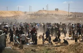 Palestinos transportan suministros de ayuda recibidos de la Fundación Humanitaria de Gaza.