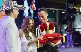 Maren García esposa de Omar Geles y Juan Manuel Geles, hermano del compositor recibiendo la corona por parte del presidente de la Fundación Vallenata. 