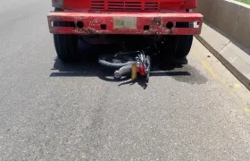 La motocicleta quedó debajo de la volqueta. 