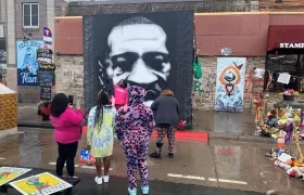 Residentes del barrio Powderhorn Park rinden homenaje al afroamericano George Floyd en la esquina en la que dejó de respirar por la asfixia causada por un exagente de Policía.