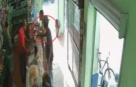 Momentos en que el joven dejaba un panfleto en una tienda en la tarde