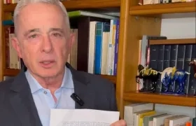 Álvaro Uribe Vélez mostrando el acta de encarcelamiento. 