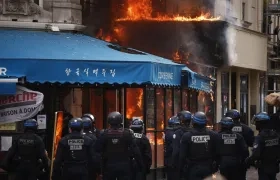Agentes de policía aseguran alrededor de un restaurante en Paris tras ser incendiado.